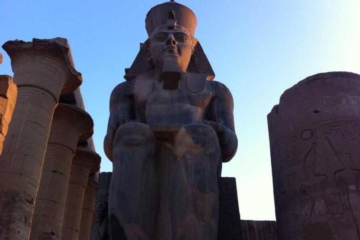 una grande statua di un uomo in piedi davanti ai banchi