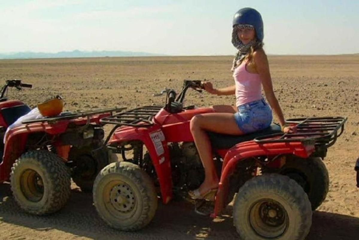 žena sediaca na štvorkolke v púšti