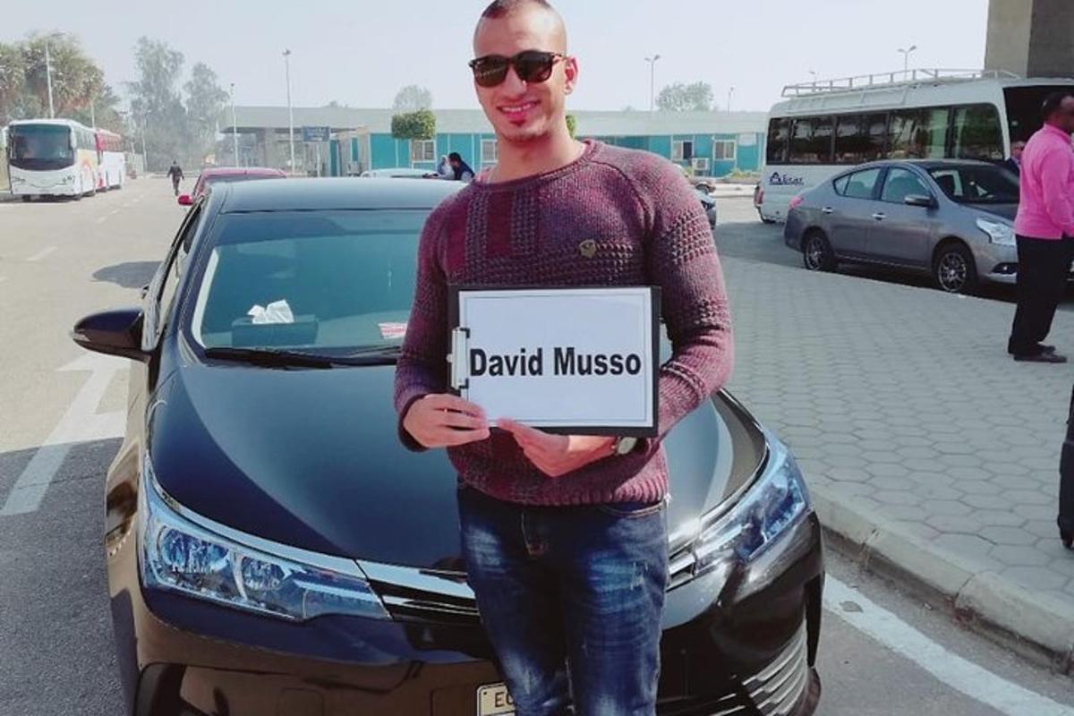 muž držící ceduli před autem