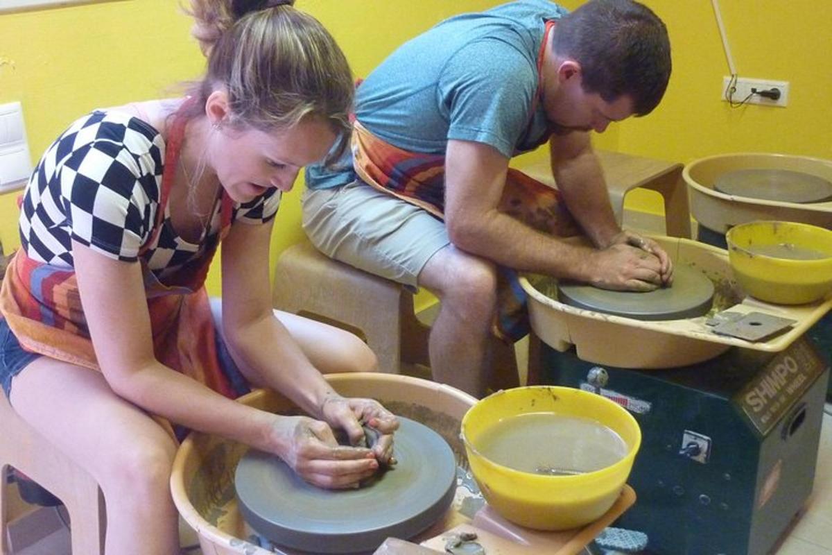 un gruppo di persone che lavorano su un tornio da vasaio