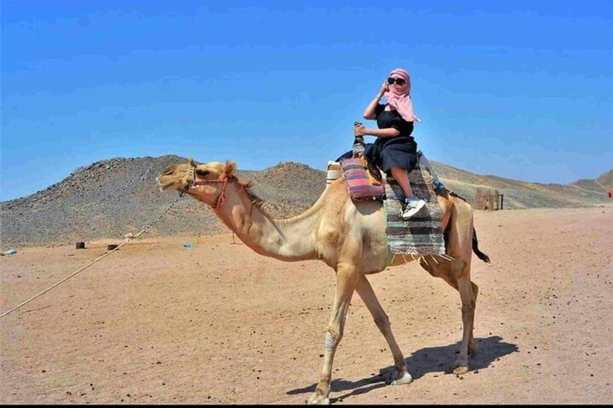 una mujer montada en un camello en el desierto