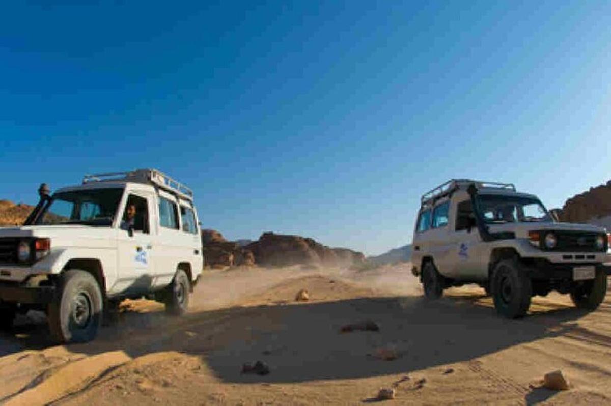 due camion parcheggiati su una strada sterrata nel deserto
