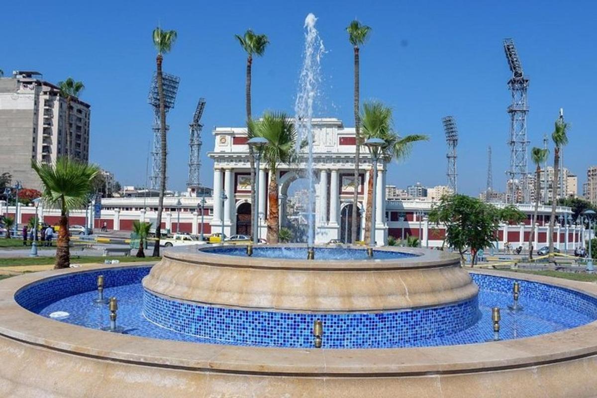 a fountain in front of a building with palm trees
