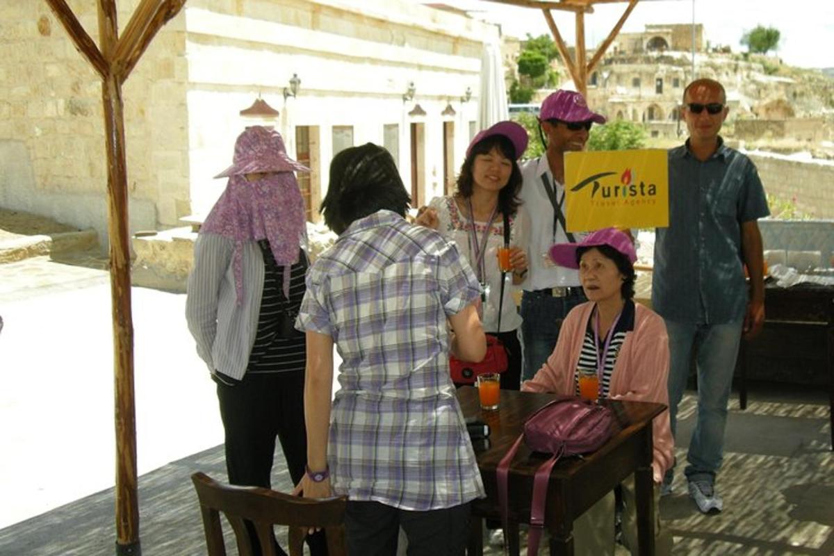 a group of people wearing turbans standing around a table