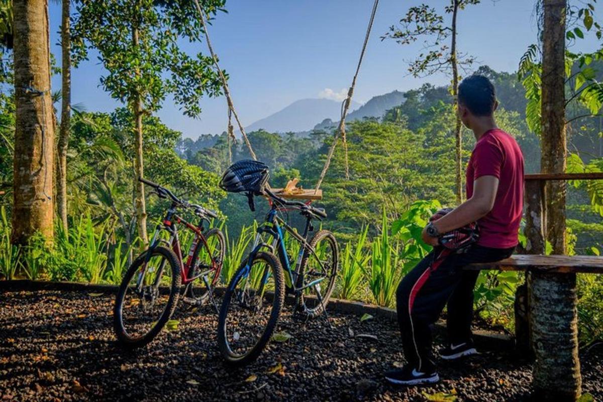 a man sitting on a bench next to two bikes