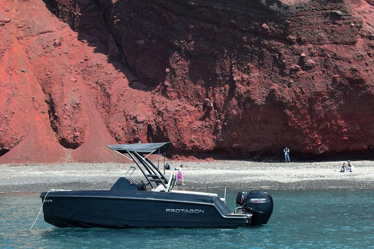 a boat sitting in the water next to a mountain