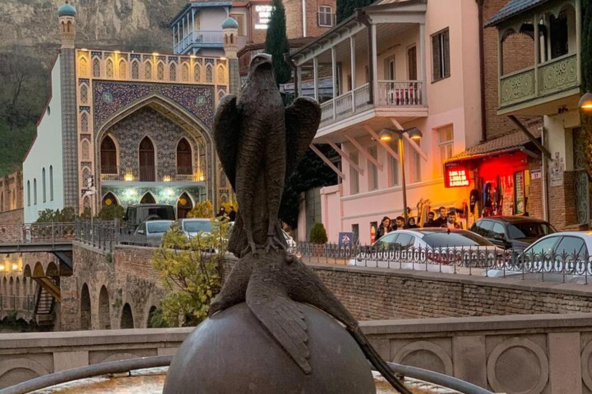 una statua di un uccello seduto in cima a una fontana