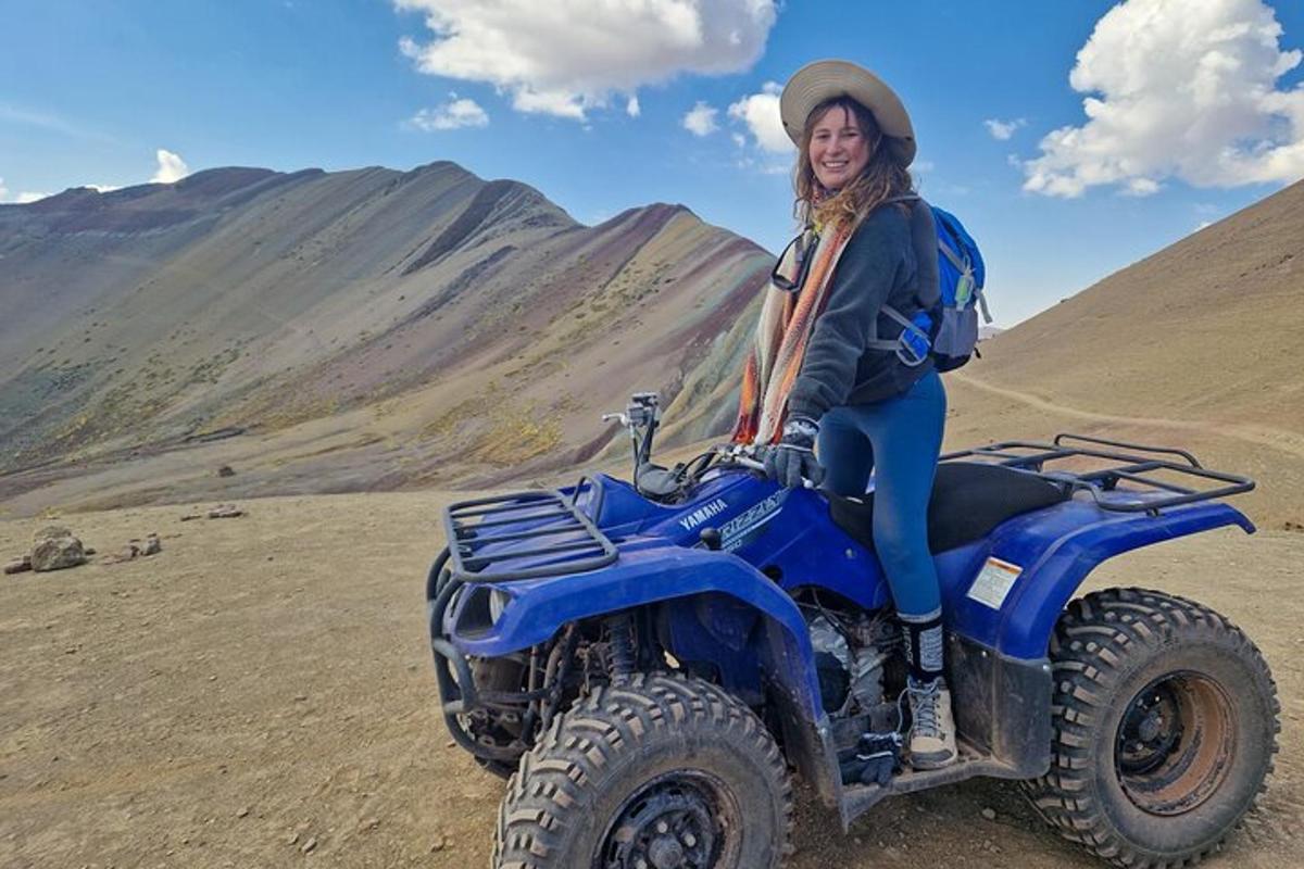 Una mujer sentada en un vehículo todo terreno azul en el desierto.