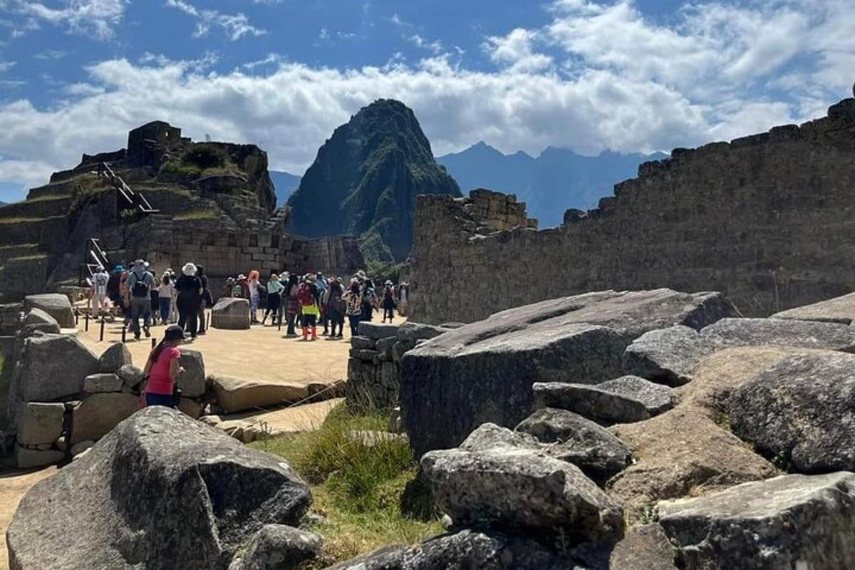 Un grupo de personas caminando alrededor de las ruinas de una montaña.