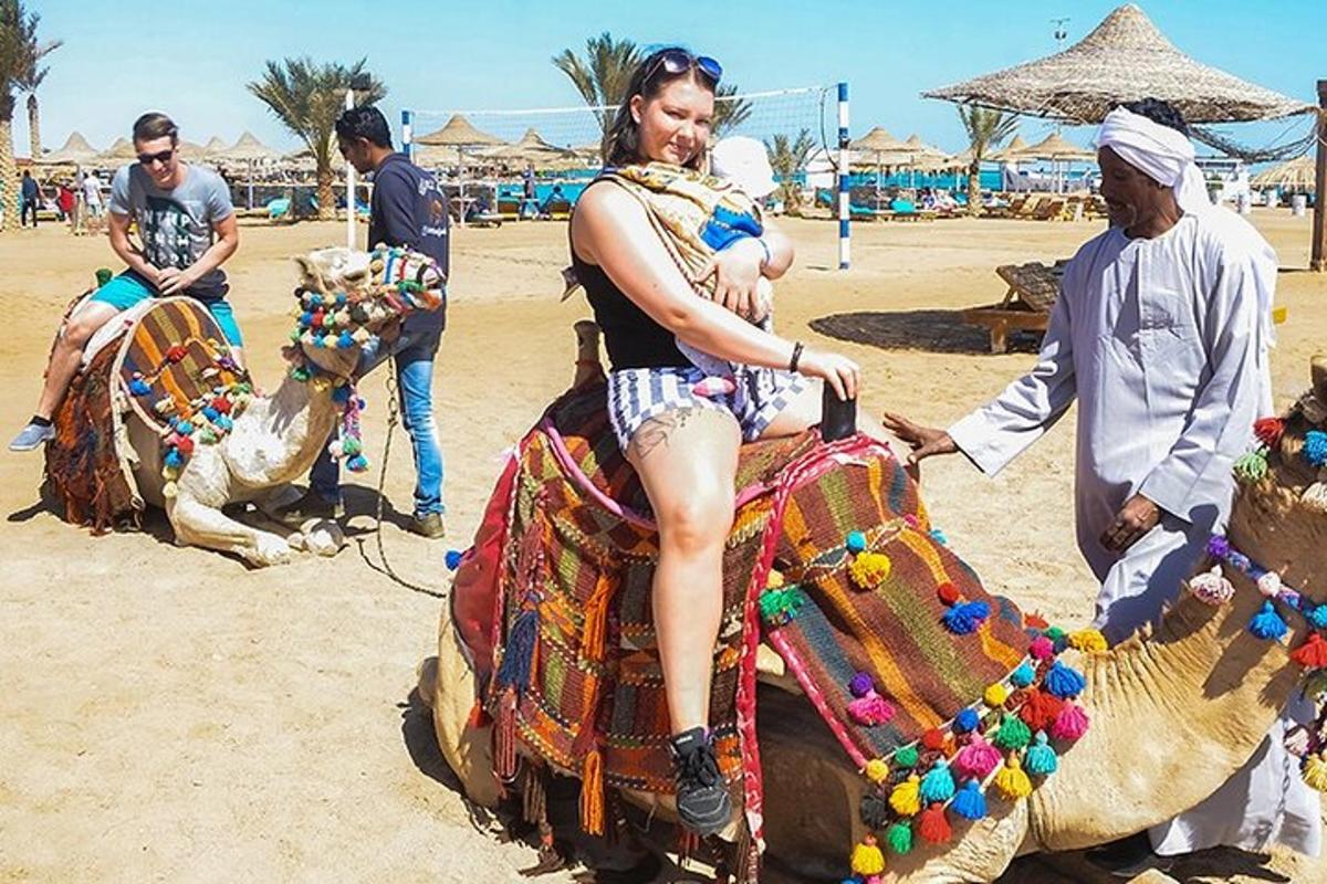 a woman is sitting on a camel on the beach
