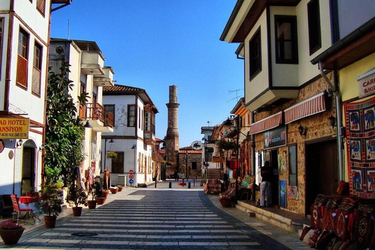 a cobblestone street in a town with a factory in the background