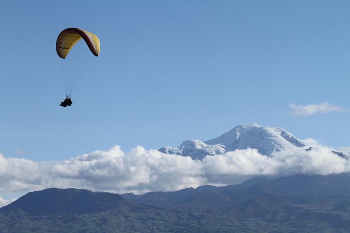 a person flying a kite in front of a mountain