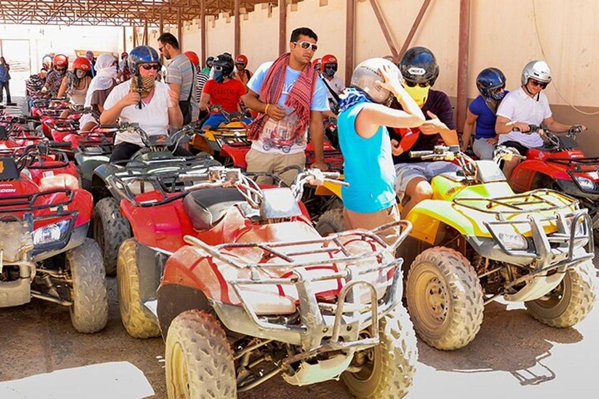 skupina lidí stojících kolem čtyřkolek a motocyklů