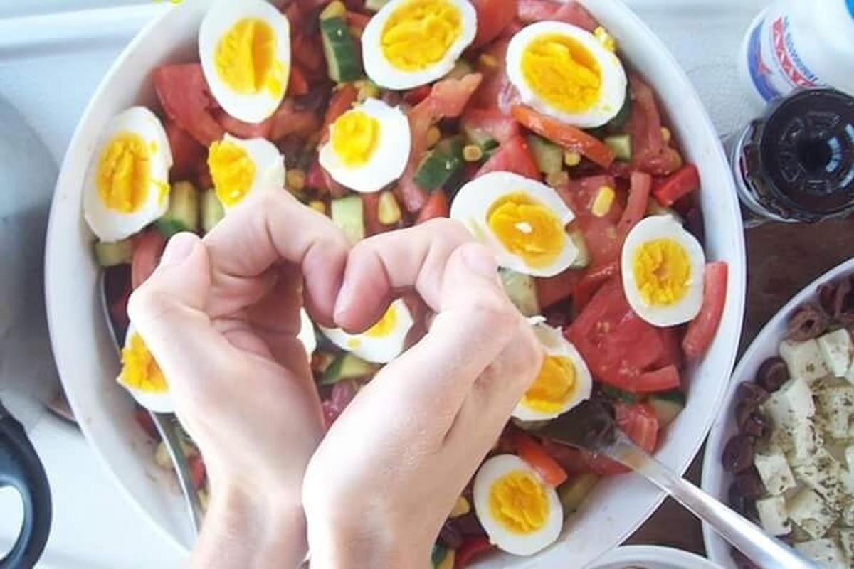 oseba, ki z rokami nad skledo jajc oblikuje srce