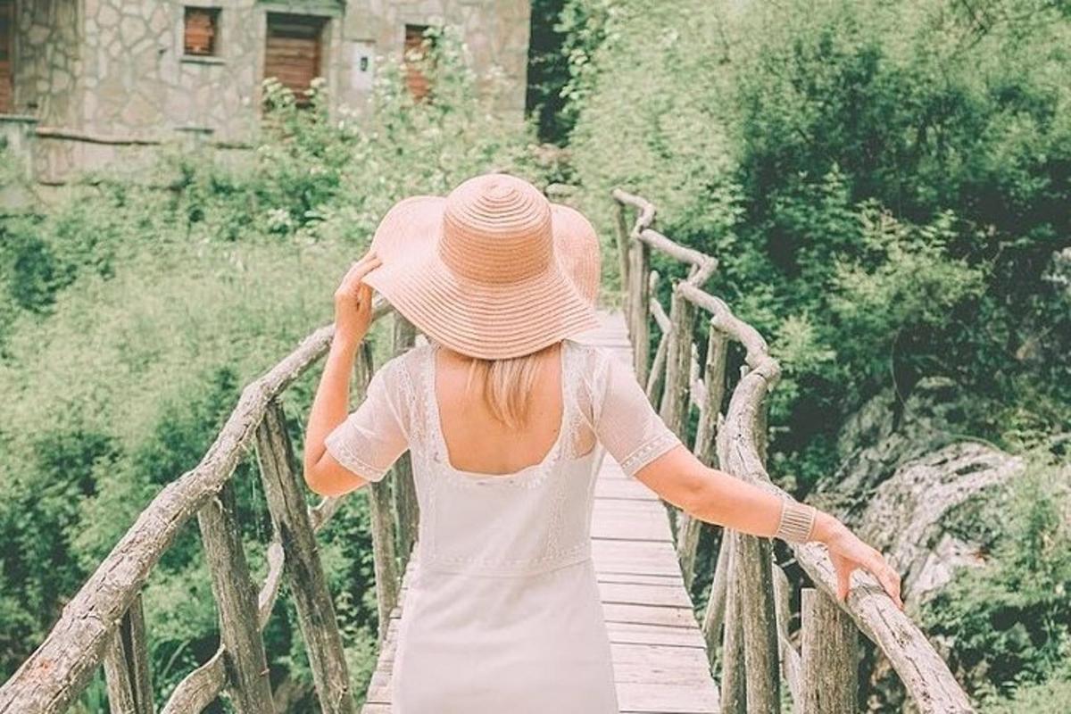 Μια γυναίκα με καπέλο περπατώντας σε μια ξύλινη γέφυρα