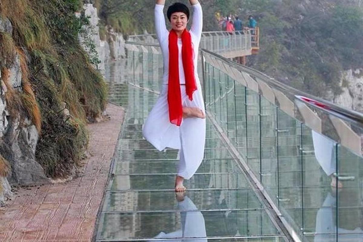 一名女子站在玻璃走道上