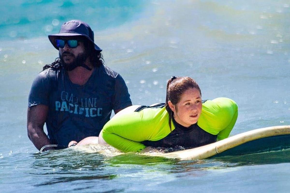 a man and a woman on a surfboard in the water