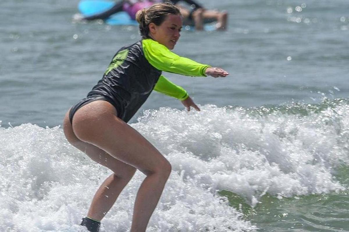 en kvinne som rir på en bølge på et surfebrett i havet