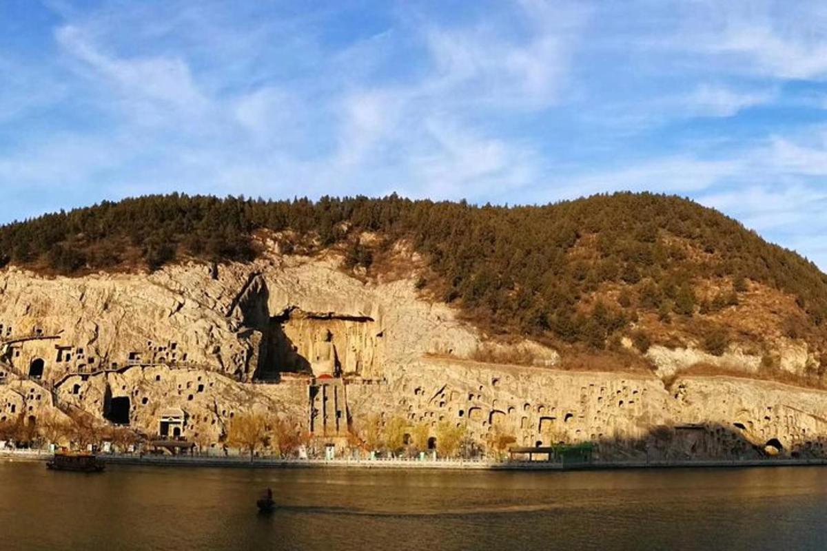 skalnatý kopec se stromy vedle vody