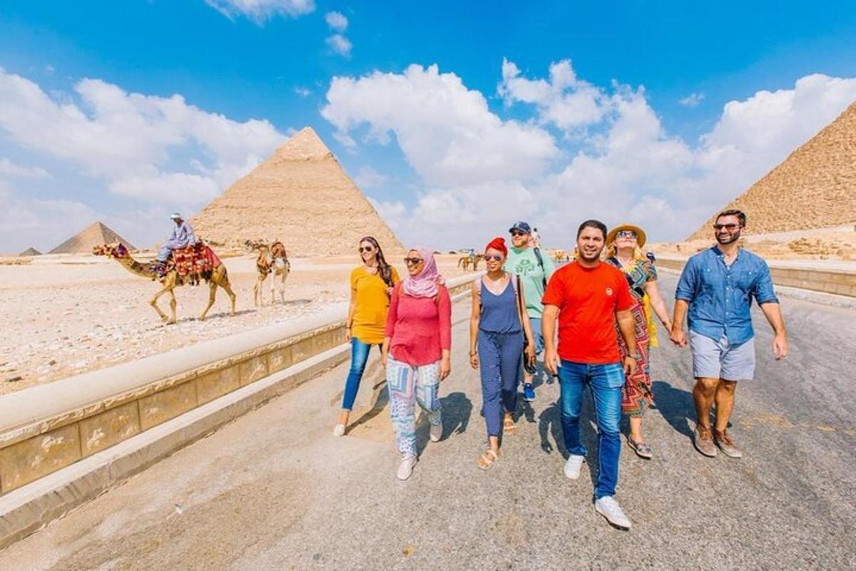 skupina lidí procházejících se před pyramidami