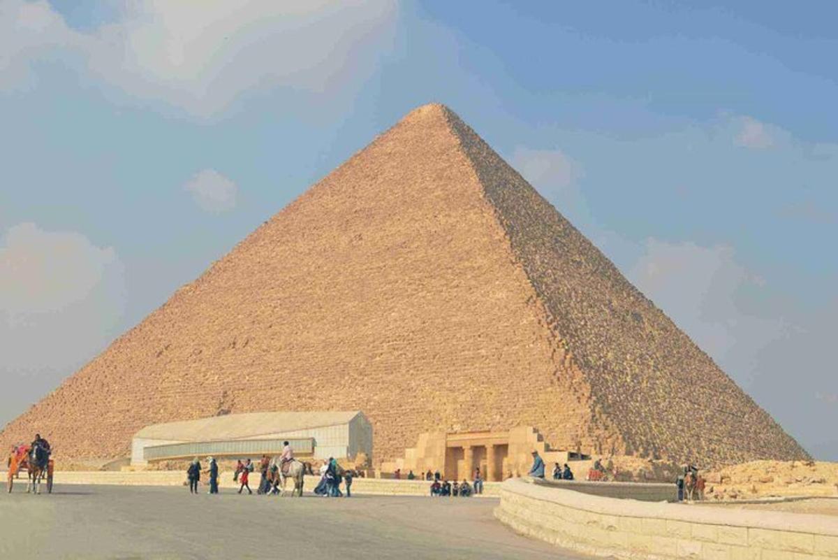 skupina lidí stojící kolem pyramidy