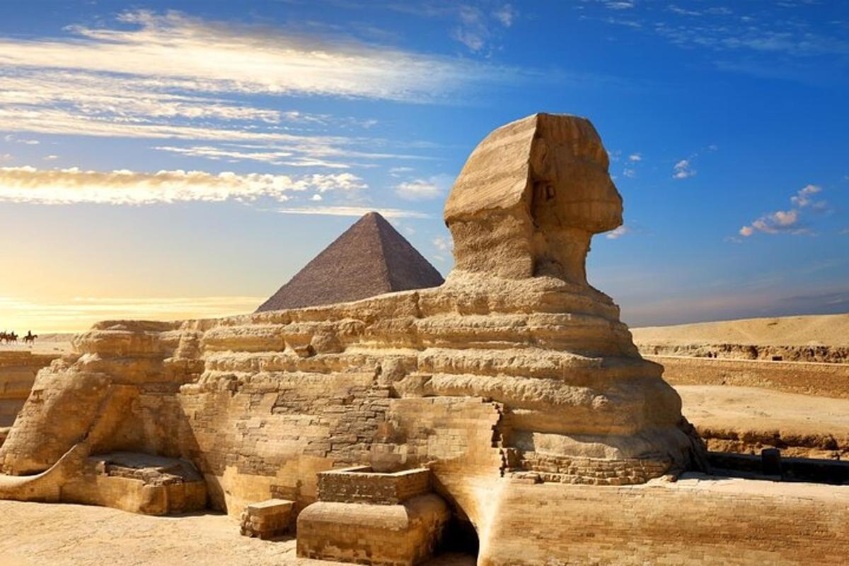 socha před sfingou a pyramidou