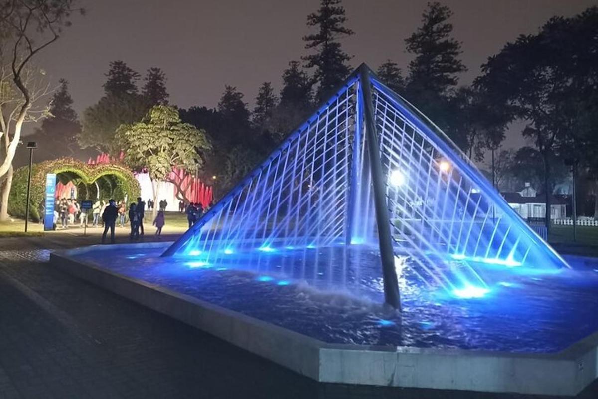 a fountain with blue lights in a park at night
