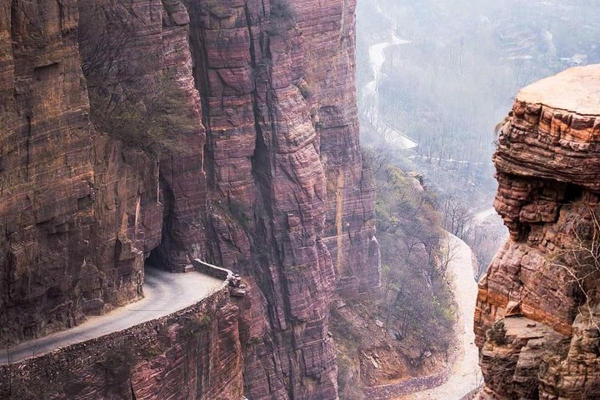 a person standing on the edge of a mountain cliff