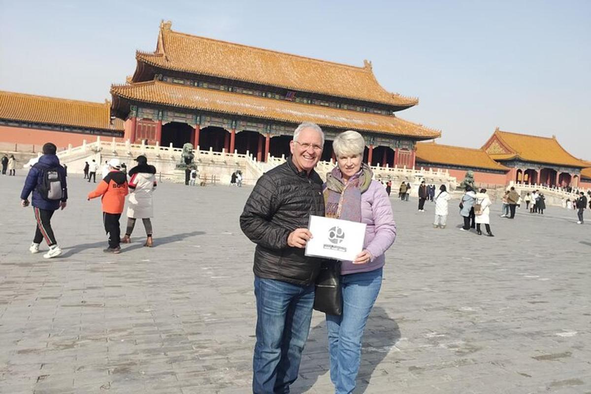 a man and a woman holding a sign in front of a building