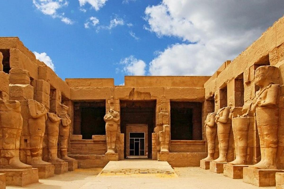 Un edificio con grandes columnas de piedra y una puerta.