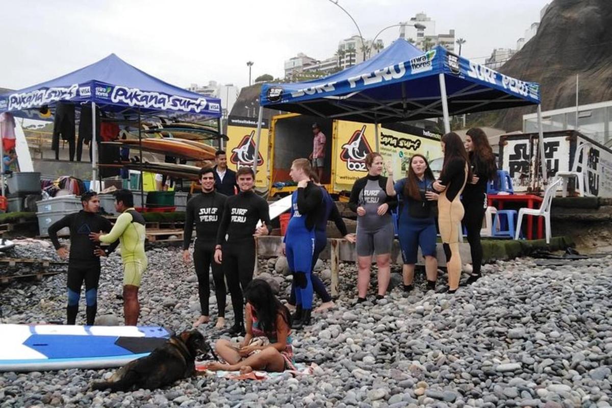 en gruppe mennesker stående på en klippefyldt strand