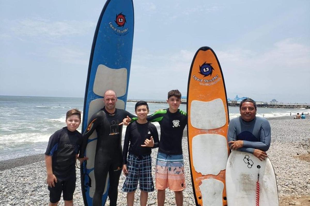 Un grupo de personas de pie en la playa con tablas de surf.