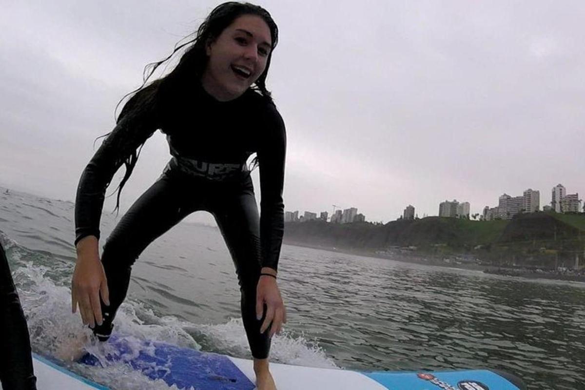 Un hombre parado sobre una tabla de surf en el agua