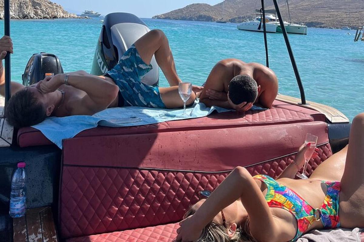 un gruppo di persone sdraiate sul retro di una barca in acqua