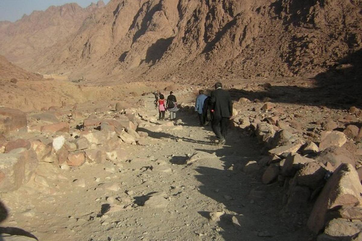 un gruppo di persone che camminano su una montagna rocciosa