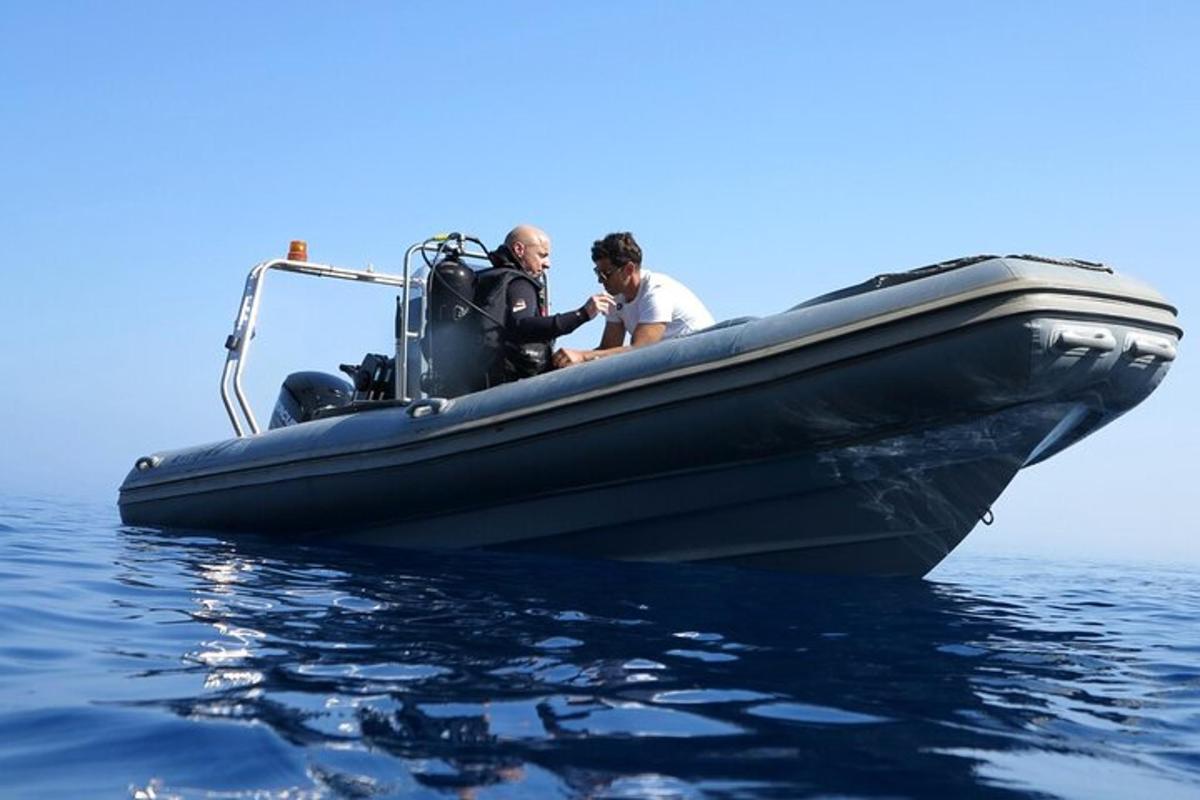 dua pria di perahu hitam di atas air