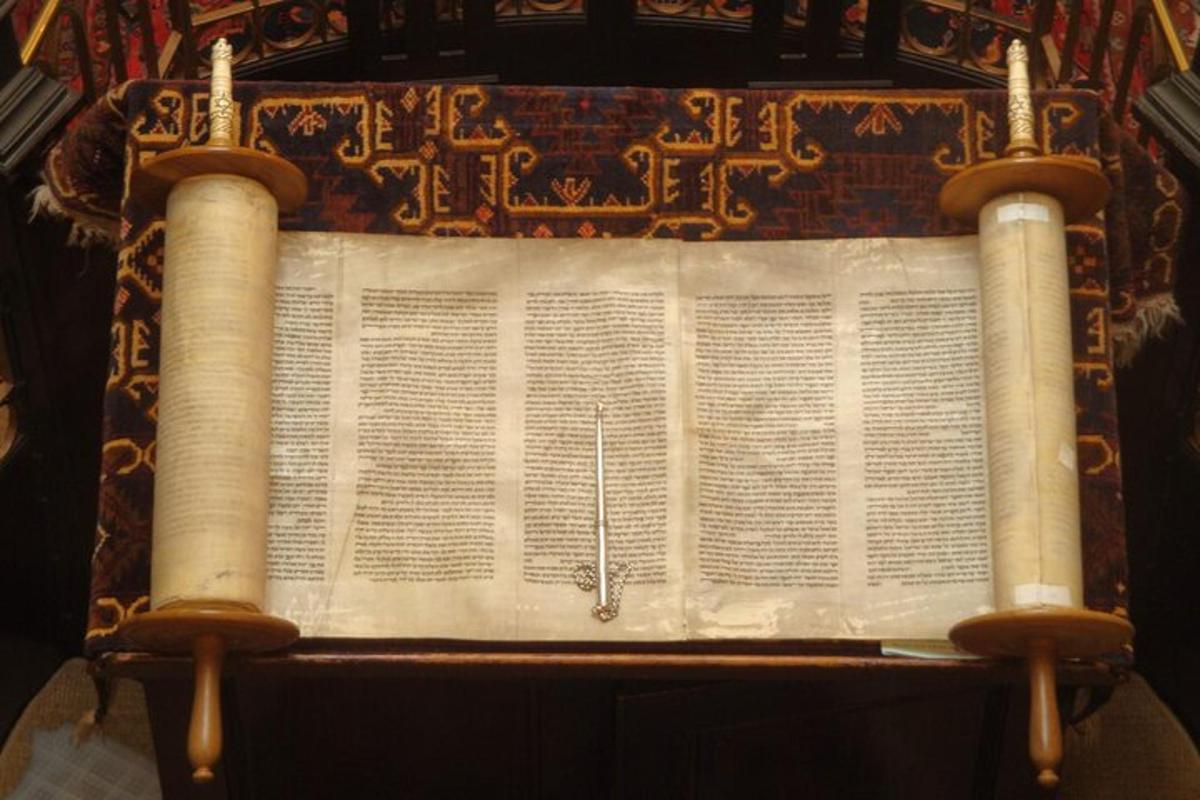 an open book with a sword on top of it
