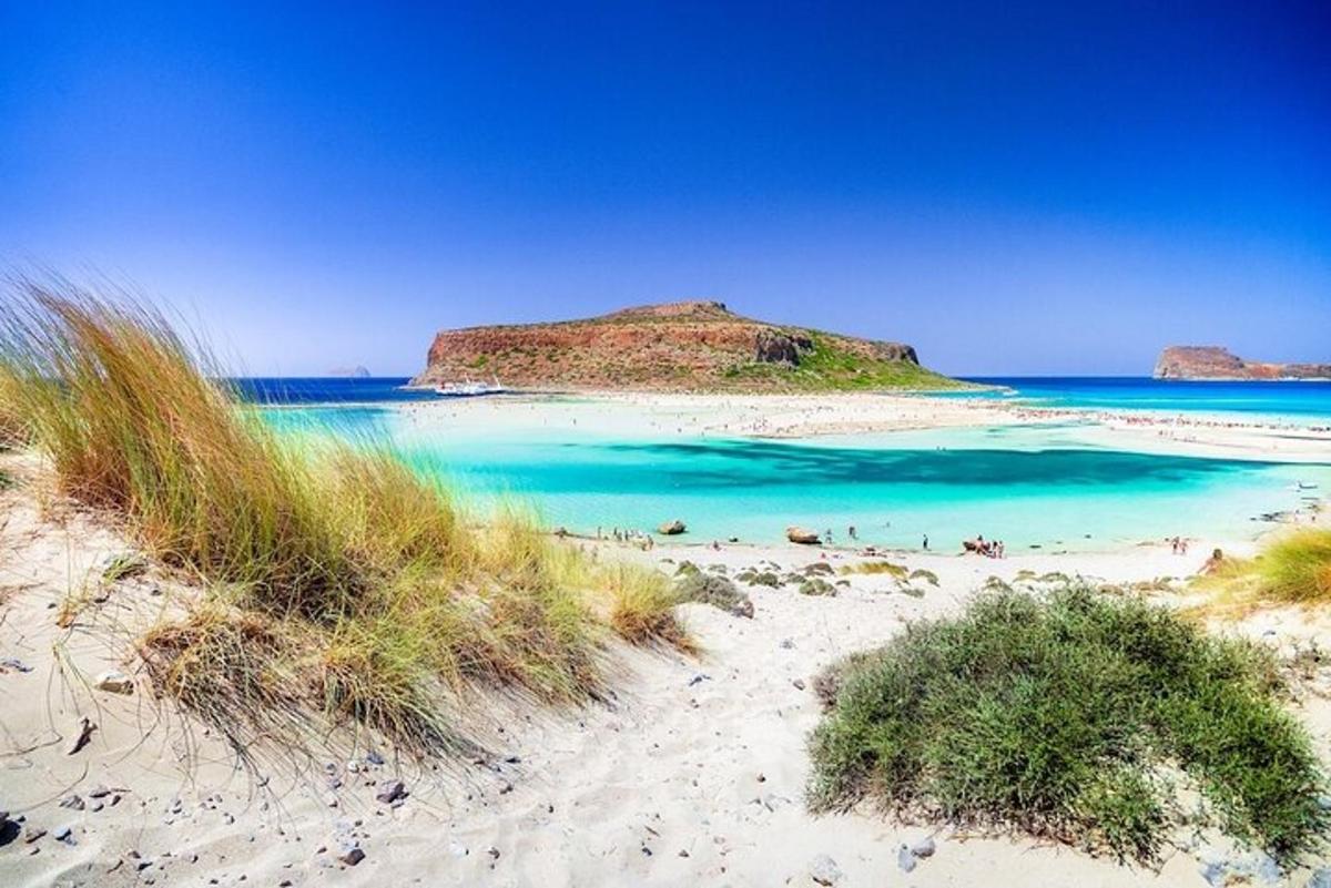 a beach with blue water and a small island