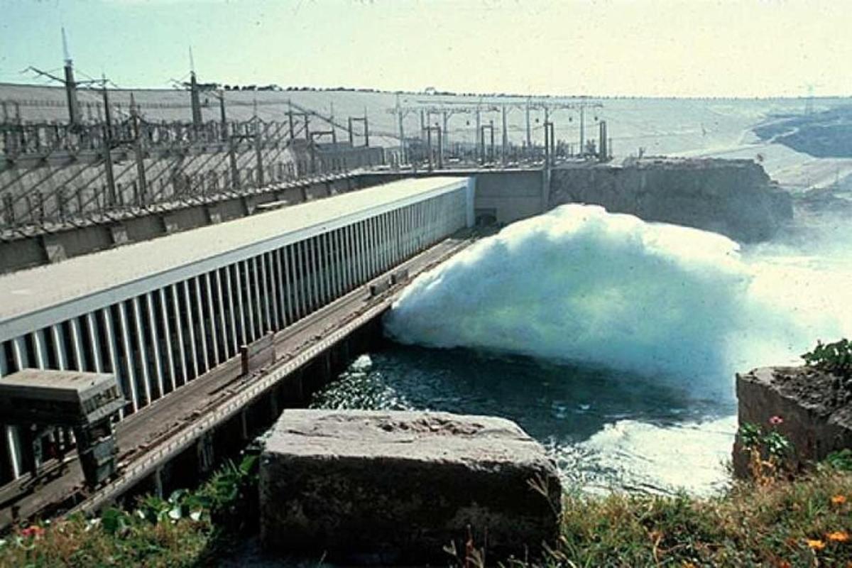 o grămadă de zăpadă în apă lângă un baraj