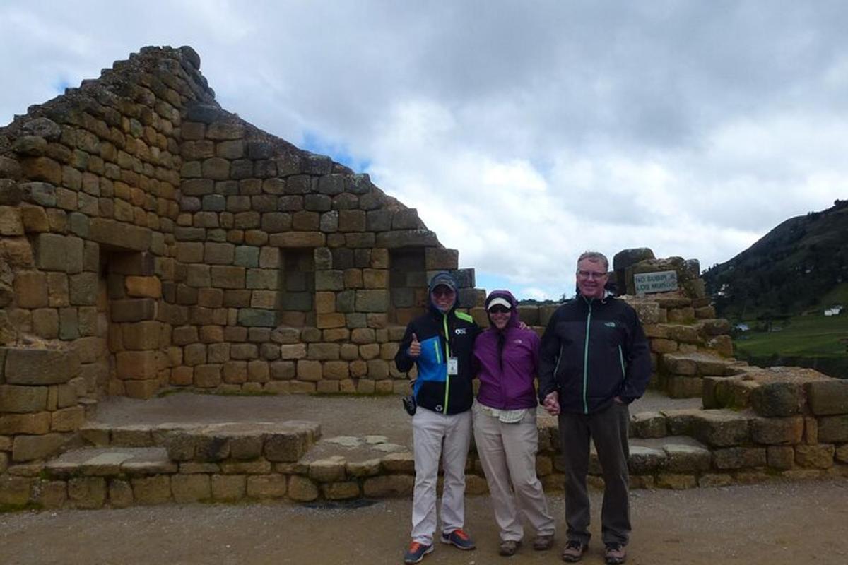 three people standing in front of a stone building