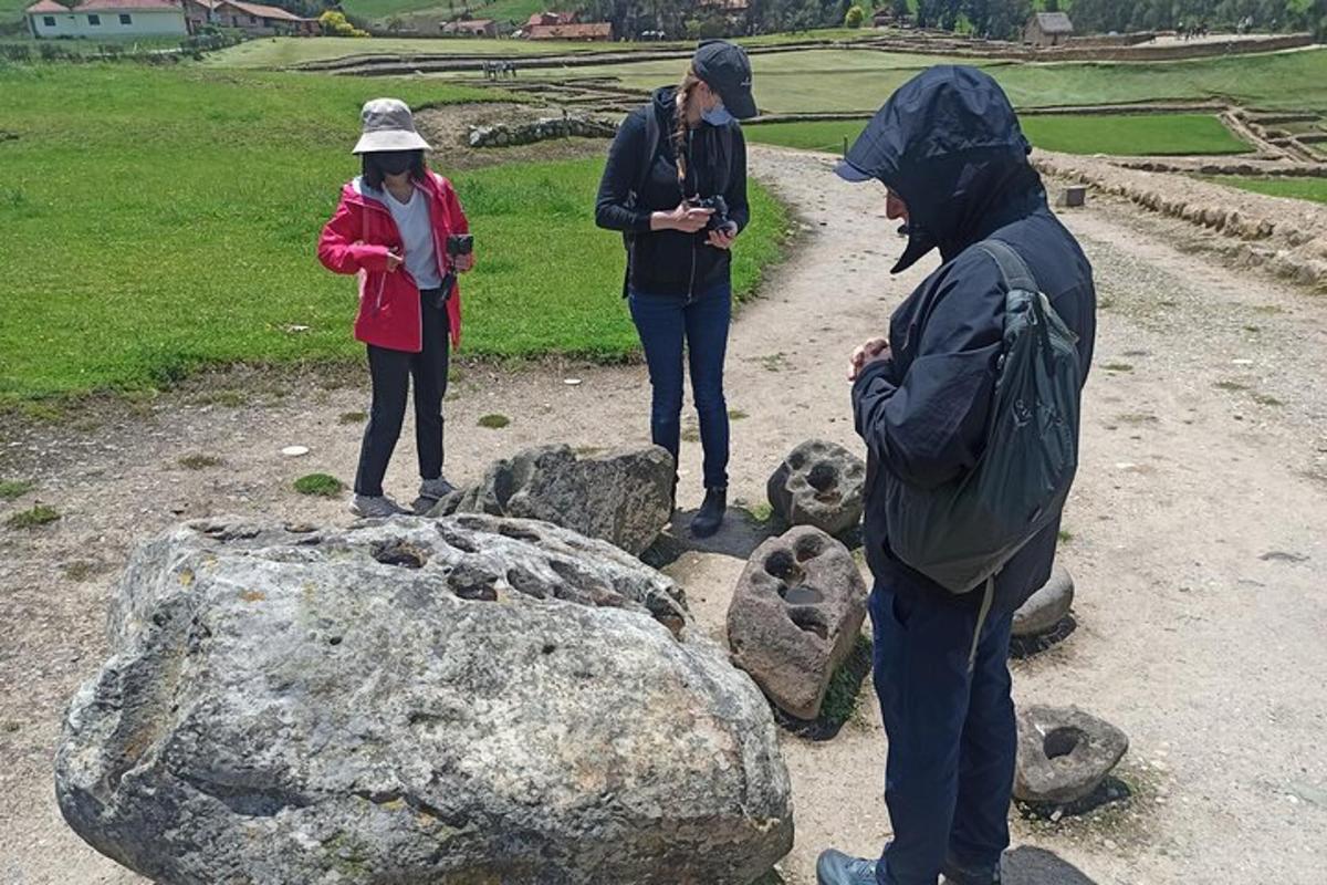a group of people standing next to a rock