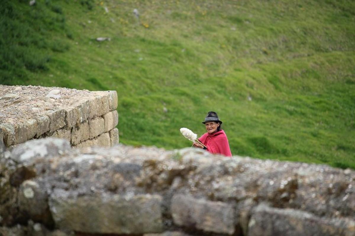 a man is standing behind a stone wall