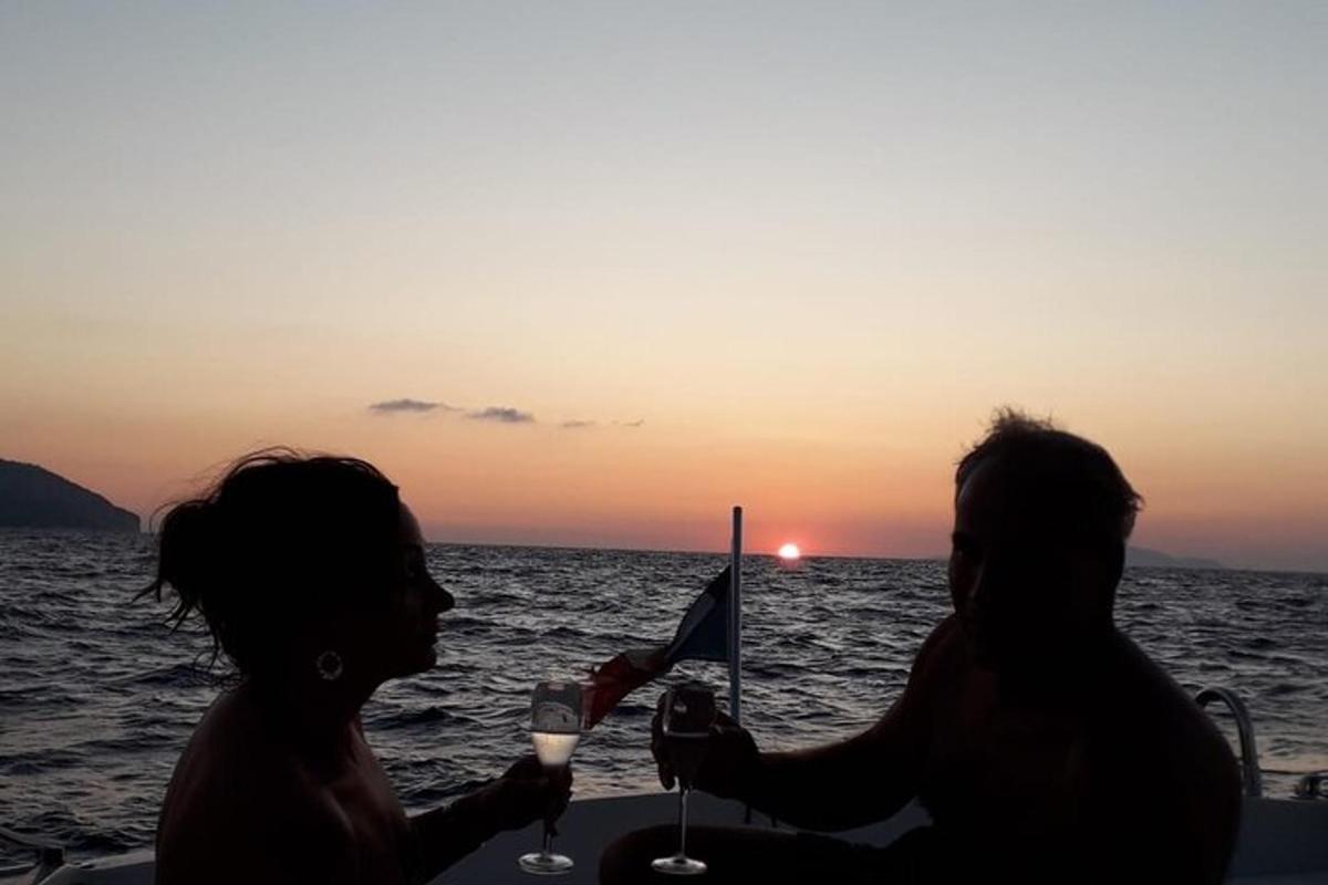 Ένας άντρας και μια γυναίκα κάθονται σε μια βάρκα με ποτήρια κρασιού