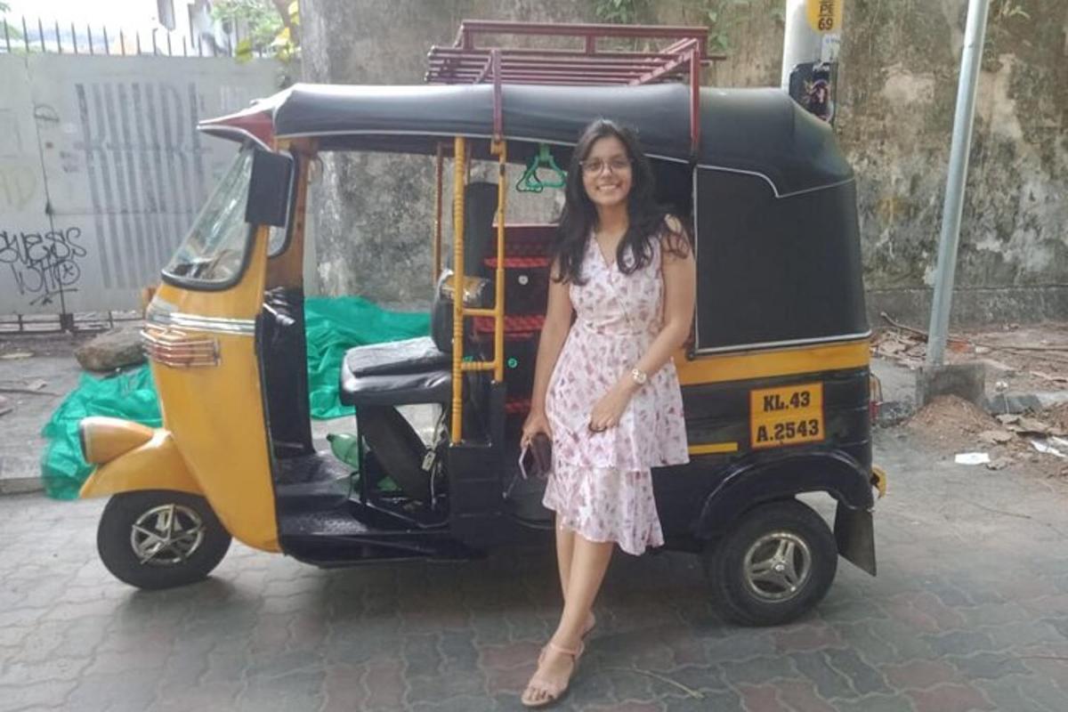 a woman in a dress standing next to a taxi