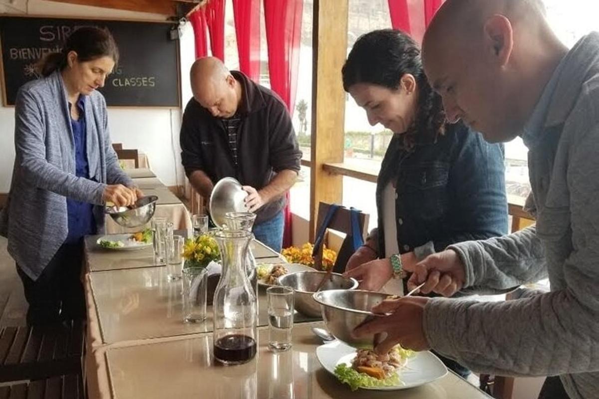 μια ομάδα ανθρώπων που στέκονται γύρω από ένα τραπέζι τρώγοντας φαγητό