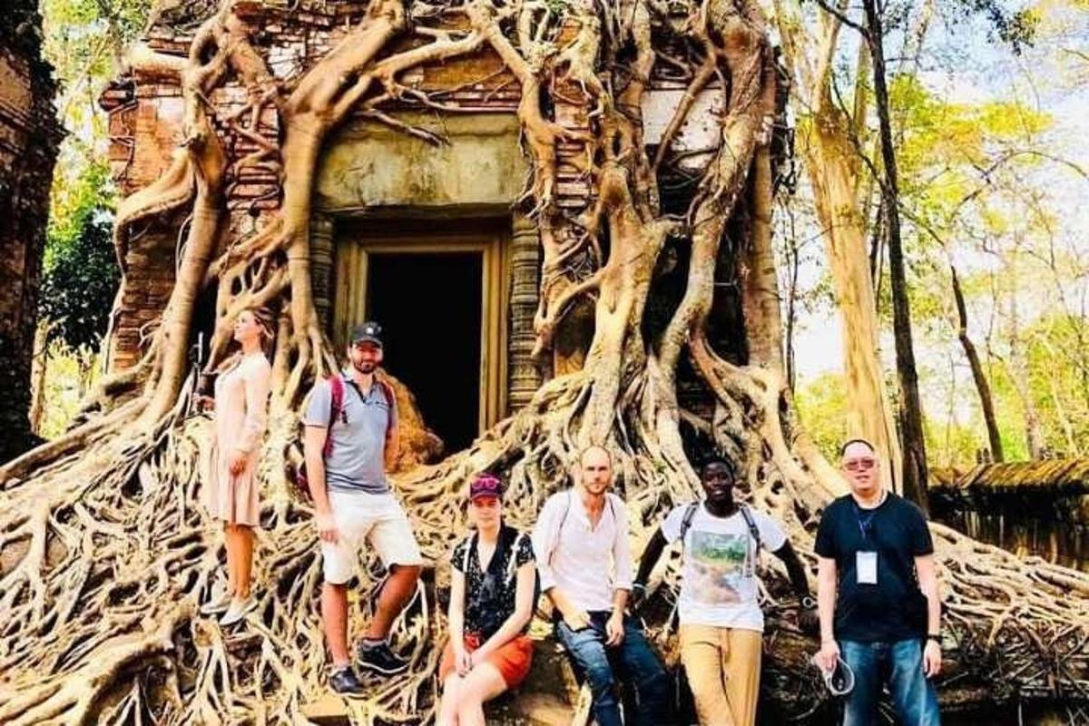 un gruppo di persone in piedi davanti a una struttura ad albero