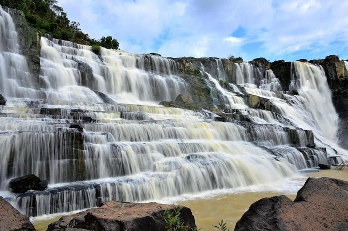 a large waterfall with water falling into a river