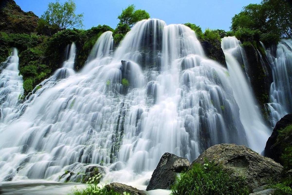 a waterfall with water cascading down a mountain