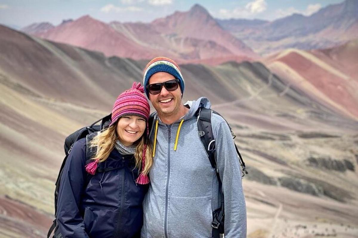 een man en een vrouw staan op de top van een berg