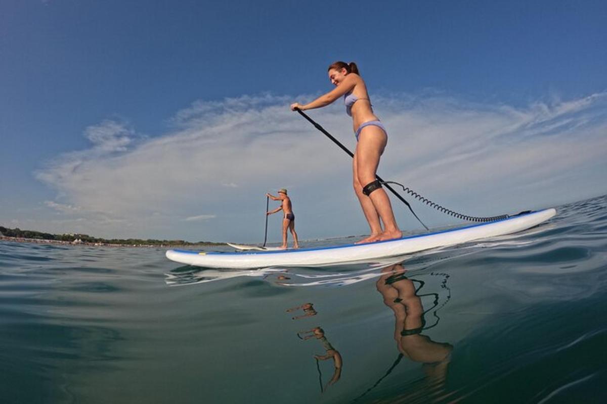 o femeie este pe o placă de paddle în apă